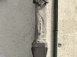 Steinfigur auf Sockel an Hausecke