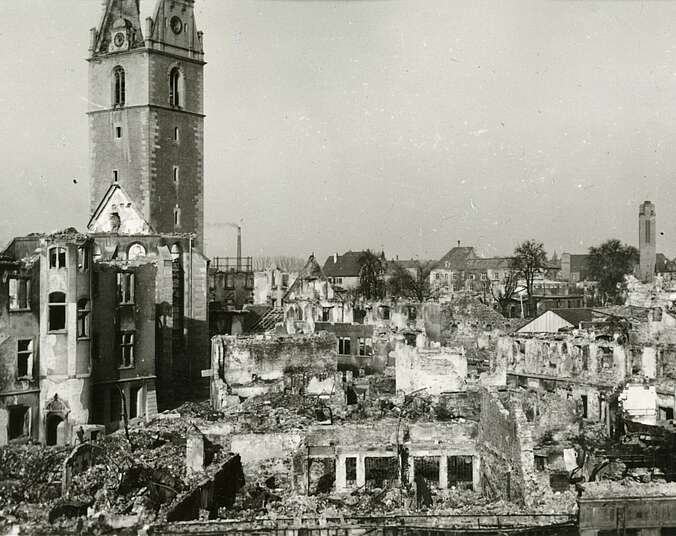 Zerbombte Innenstadt mit Nikolauskirche im Vordergrund
